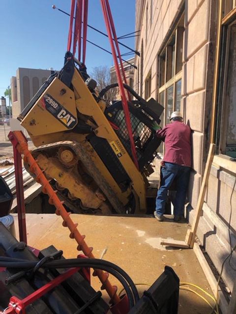 Skid Steer Being Lowered Through Sidewalk